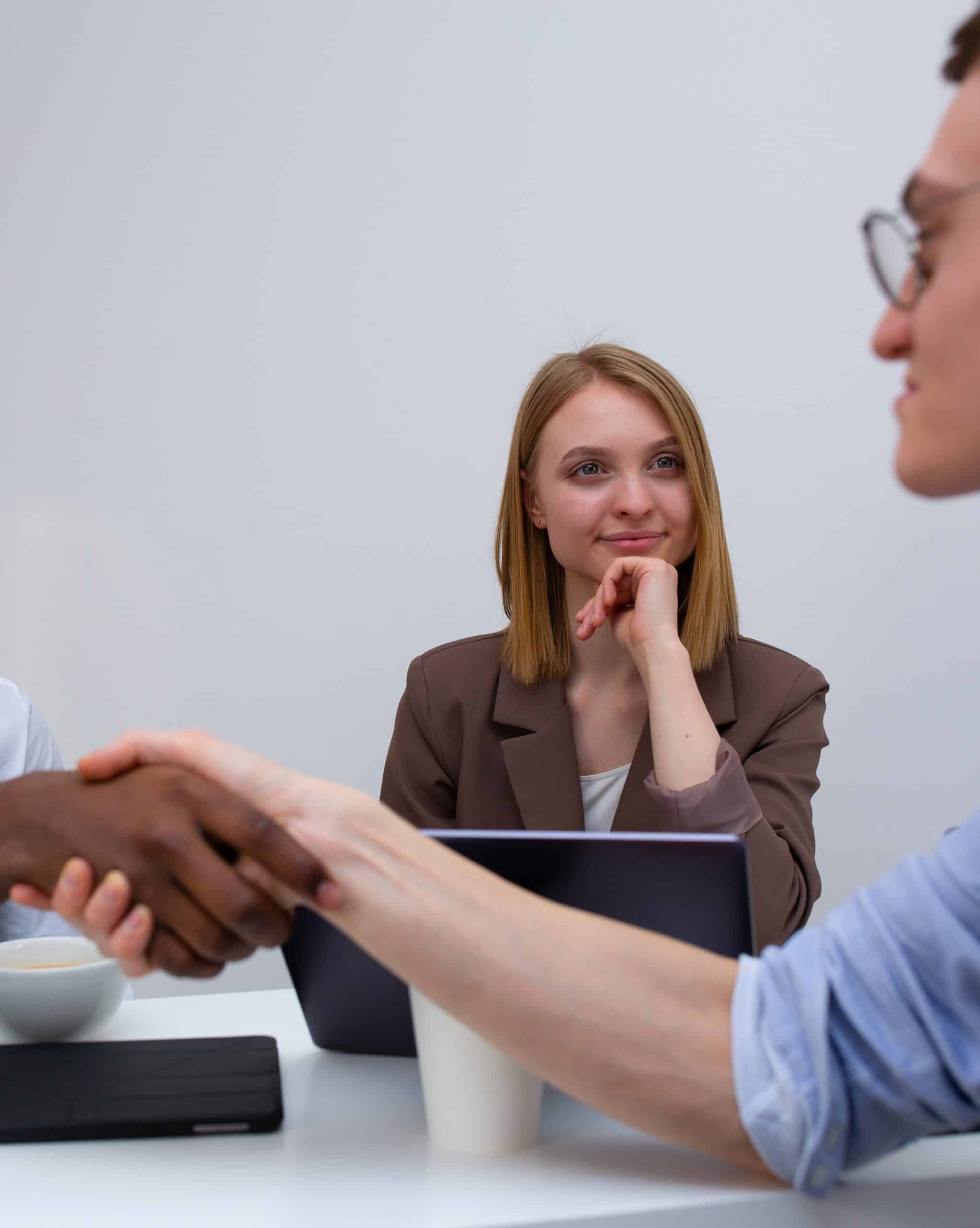 Picture of a woman observing an applicant shake hands with an interviewer